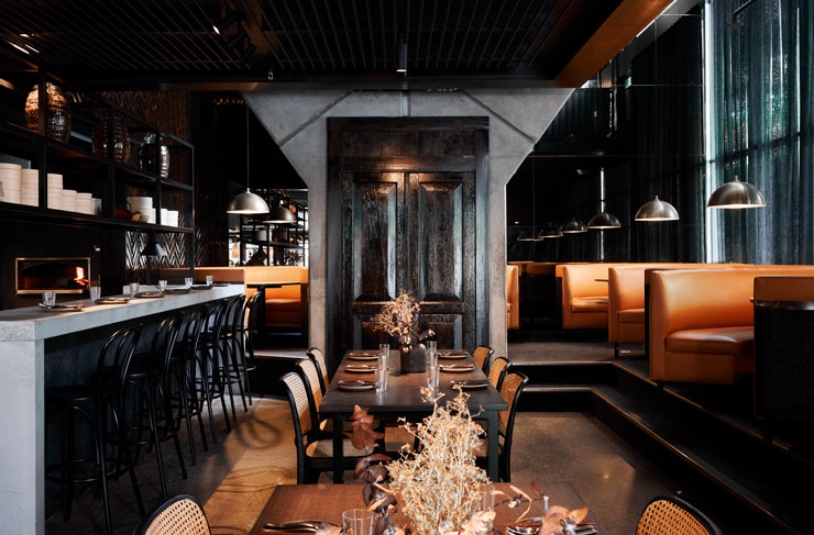 The sleek black and orange-hued interior at Wilma restaurant in Canberra.
